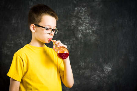 Teenage boy drinking fruit juice wearing yellow t-shirtの写真素材