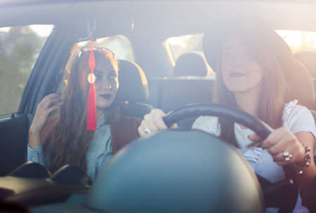 Two girl friends taking a road trip by carの写真素材