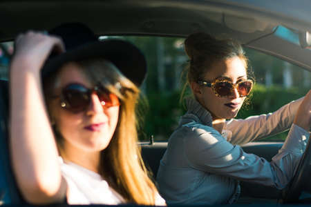 Two girl friends taking a road trip by carの写真素材