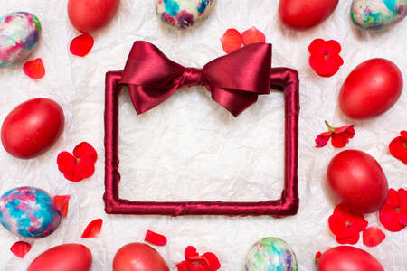 Empty red frame and painted Easter eggs on whiteの写真素材