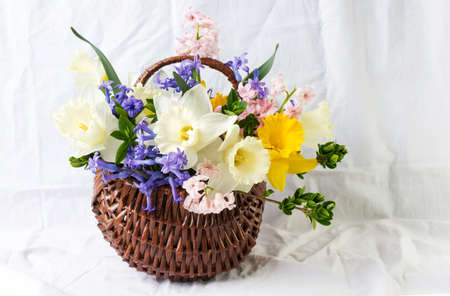 Colorful spring flowers in a wicker basket. Home decorationの写真素材