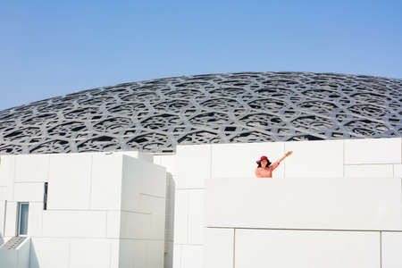 ABU DHABI, UNITED ARAB EMIRATES - JANUARY 26, 2018: Happy tourist in Louvre Abu Dhabi building on a...
