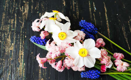 Colorful spring flowers mixed bouquet on a wooden tableの写真素材