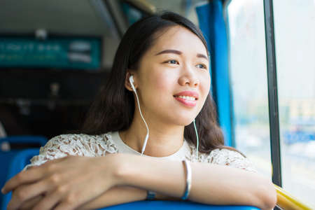 Girl listening to music on a public bus rideの写真素材