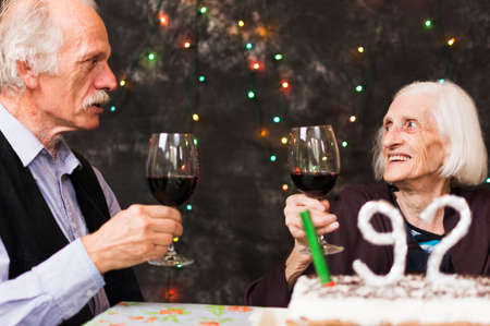 Senior people toasting with alcohol on a birthday celebrationの写真素材