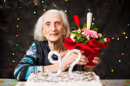 Senior woman holding a  present on birthday celebrationの写真素材