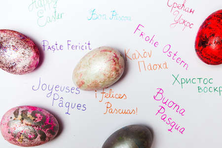 Happy Easter card on various languages with homemade painted eggsの写真素材