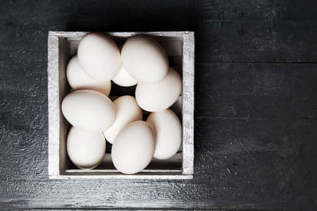 White chicken eggs in a wooden bowの写真素材