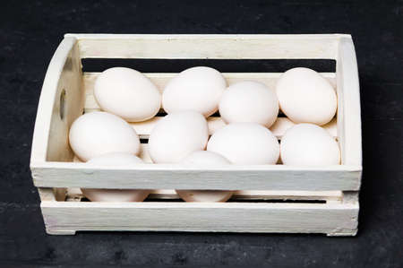 White chicken eggs in a wooden bowの写真素材