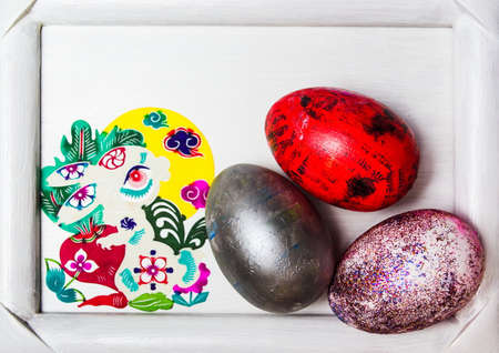 Painted Easter eggs in a picture frame top viewの写真素材