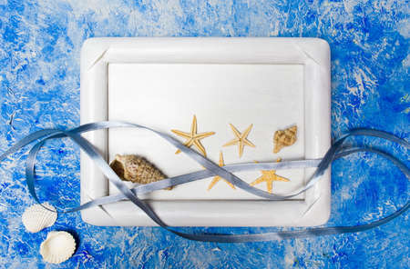 Seaside objects in a photo frame against blue backgroundの写真素材