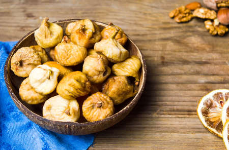 Dry figs in a rustic coconut bowl tabletop shotの写真素材
