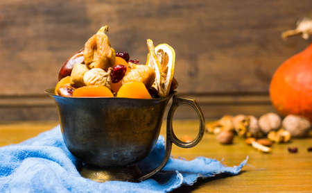 Various dried fruits in a vintage copper cupの写真素材