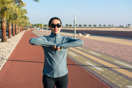 Girl warming up on a running track before workout. Active lifestyle