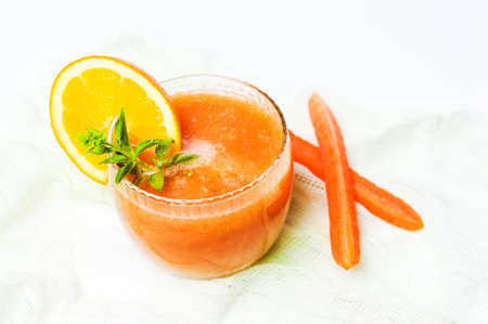 Healthy carrot and orange smoothie in a glass isolatedの写真素材