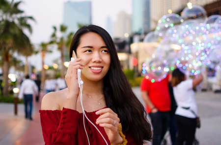 Girl using phone while charging on the power bank outdoorsの写真素材