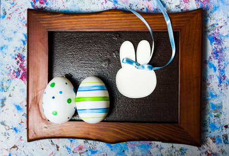 Colorful Ester eggs in a photo frame on blue background