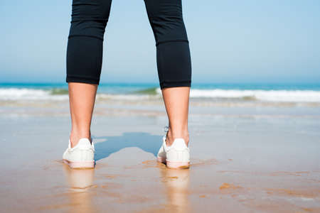Close up of a female jogger standing on the beachの写真素材