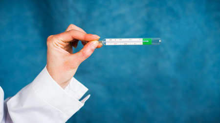 Doctor holding a body thermometer close upの写真素材