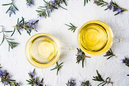 Rosemary tea with fresh plant and blossom top viewの写真素材