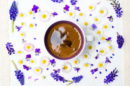 Coffee cup and fresh spring flowers on white background flat layの写真素材