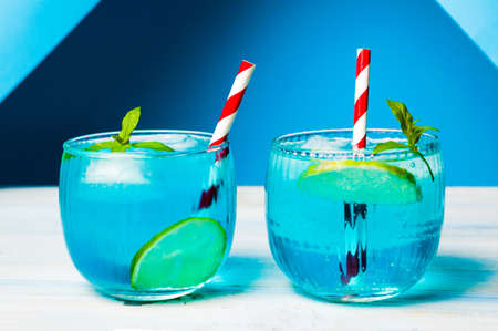 Blue cocktails decorated with lemon on matching backgroundの写真素材