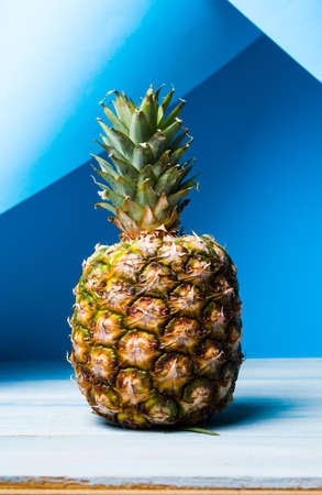 Whole pineapple fruit against blue backgroundの写真素材