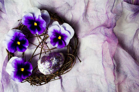 Violet flowers arrangement on purple textile top view