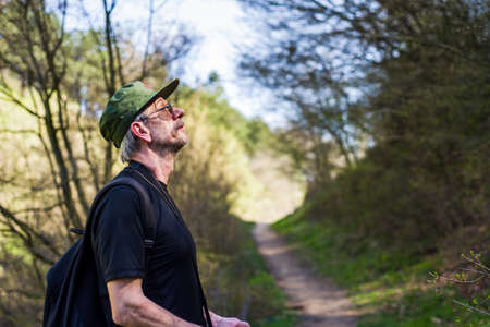 Senior man enjoying nature on a hiking tripの写真素材