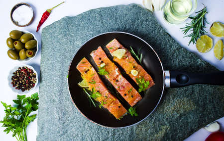 Salmon slices on a pan with cooking ingredients top viewの写真素材