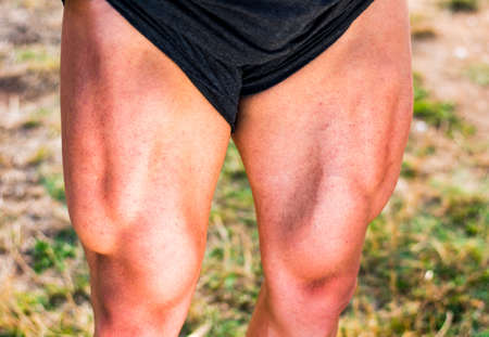 Young bodybuilder showing shaped quadriceps muscles outdoorsの写真素材