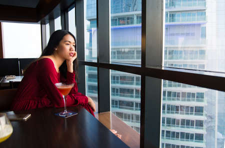 Pensive girl having a drink alone in a barの写真素材