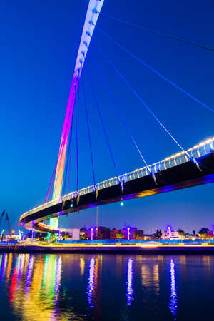 Dubai water canal bridge reflected in the water at night