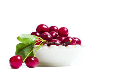 Fresh cherries in a white bowl isolated