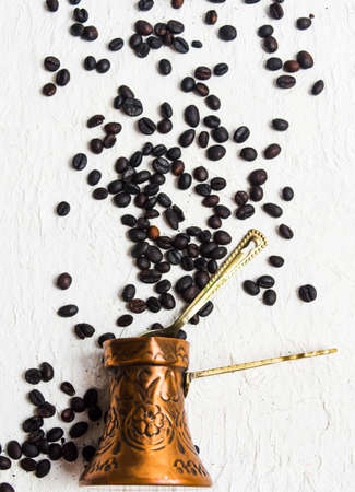 Roasted coffee beans and a copper cooking potの写真素材