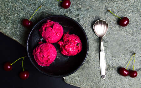 Cherry ice cream scoops on a plate top view