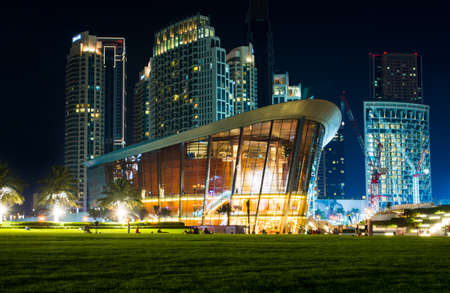 Dubai, United Arab Emirates - May 18, 2018: Dubai opera building and modern skyscrapers of the Dubai mall surroundings at nightのeditorial素材