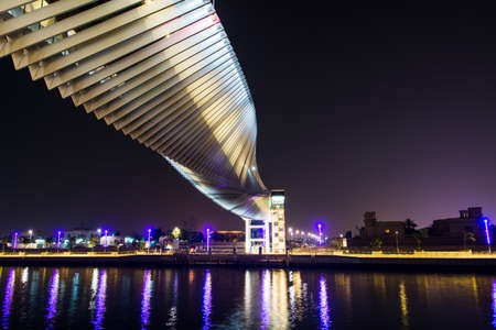 Dubai, United Arab Emirates - May 31, 2018: Dubai Water canal modern footbridge reflected in the water at nightのeditorial素材