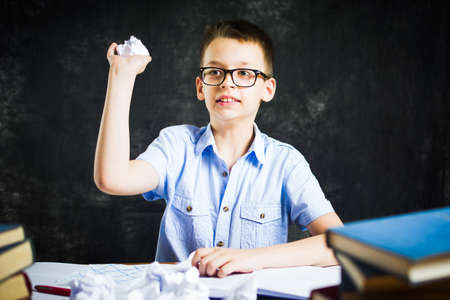 Schoolboy throwing out failed homework solutions at home