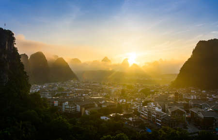 Sunrise in Yangshuo China over the karst rocks and the cityの写真素材