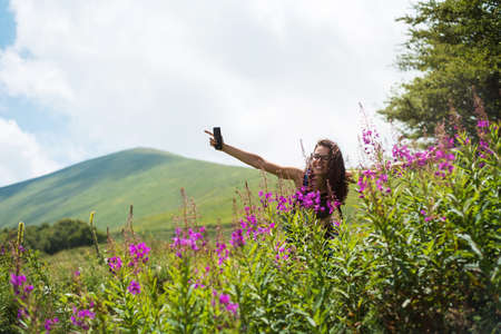 Brunette among colorful field flowers outdoorsの写真素材