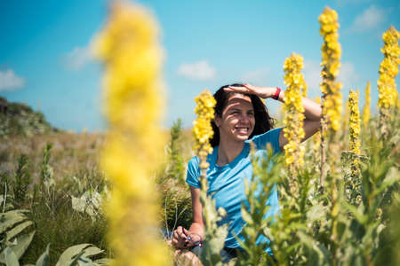Brunette among colorful field flowers outdoors