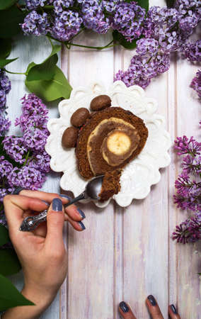 Girl eating chocolate banana cake on lilac decorated table