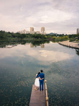 Loving couple standing on the dock at the lakeの写真素材