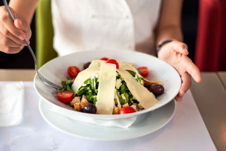 Female eating salad in the restaurant close up
