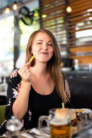 Girl having a burger in the restaurant