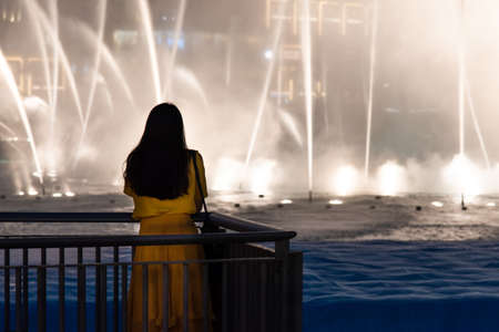 Woman with Dubai mall fountain show view at nightの写真素材