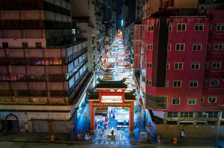 Hong Kong - August 7, 2018: Temple street night market entrance gate in Hong Kong with many shops and visitors at nighのeditorial素材