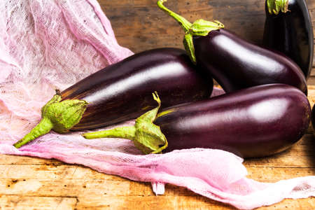 Raw Eggplant on a rustic wooden tableの写真素材