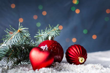 Red Christmas ornaments and fir branch with festive backgroundの写真素材